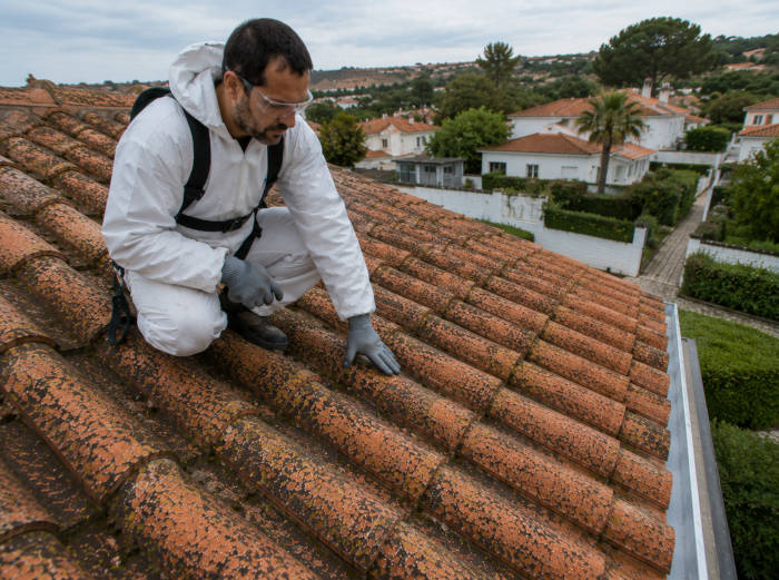 Um especialista em impermeabilização de telhados examina algumas telhas numa casa em Albufeira