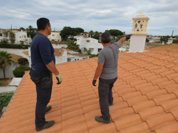 Dois trabalhadores inspecionam um telhado no Algarve